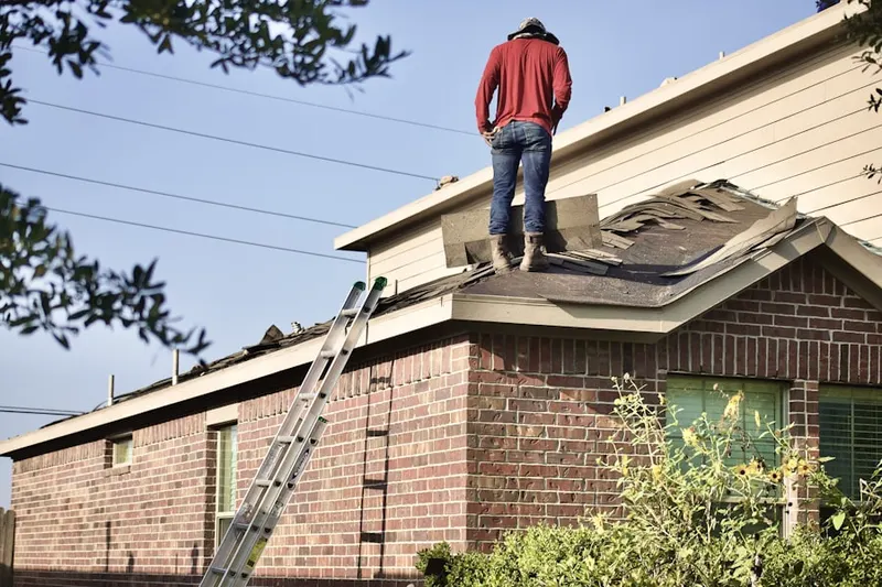 Professional roofer working on a residential roof in Lloydville